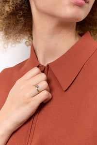 a young woman wearing solid gold jewellery with a london blue topaz gemstone