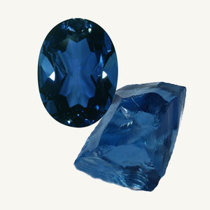 a facet-cut London blue topaz and a raw  london blue topaz gemstone on a beige background