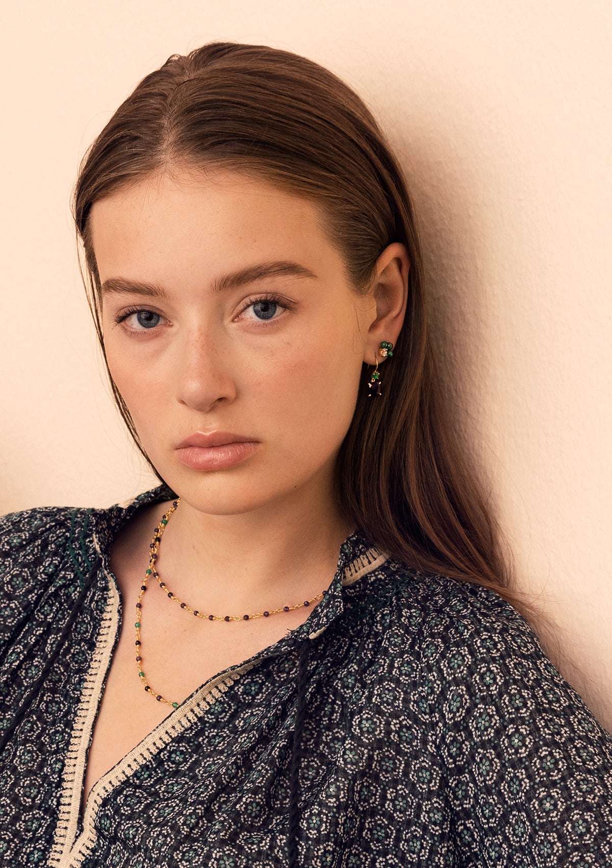 woman wearing gold plated jewellery from carré with malachite earrings and amethyst necklace.