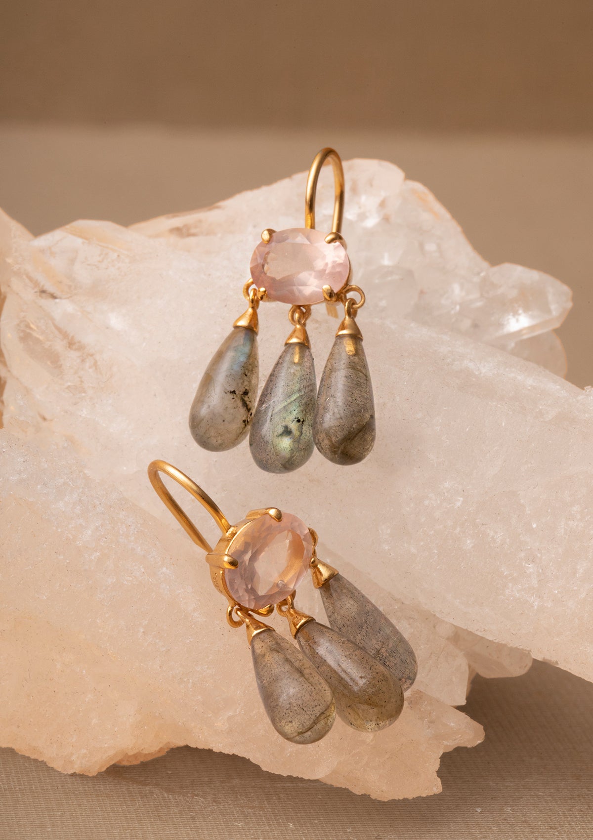 Large gold plated earrings from carré. The earrings are set with a large rose quartz gemstone and three long labradorite drops