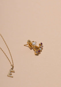 gold jewellery with stones from carré. A diamond pendant for necklaces with the letter E and an earring with pearl and ruby