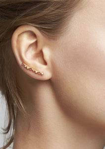 Woman with a gold earring with ruby stones and freshwater pearls from carré