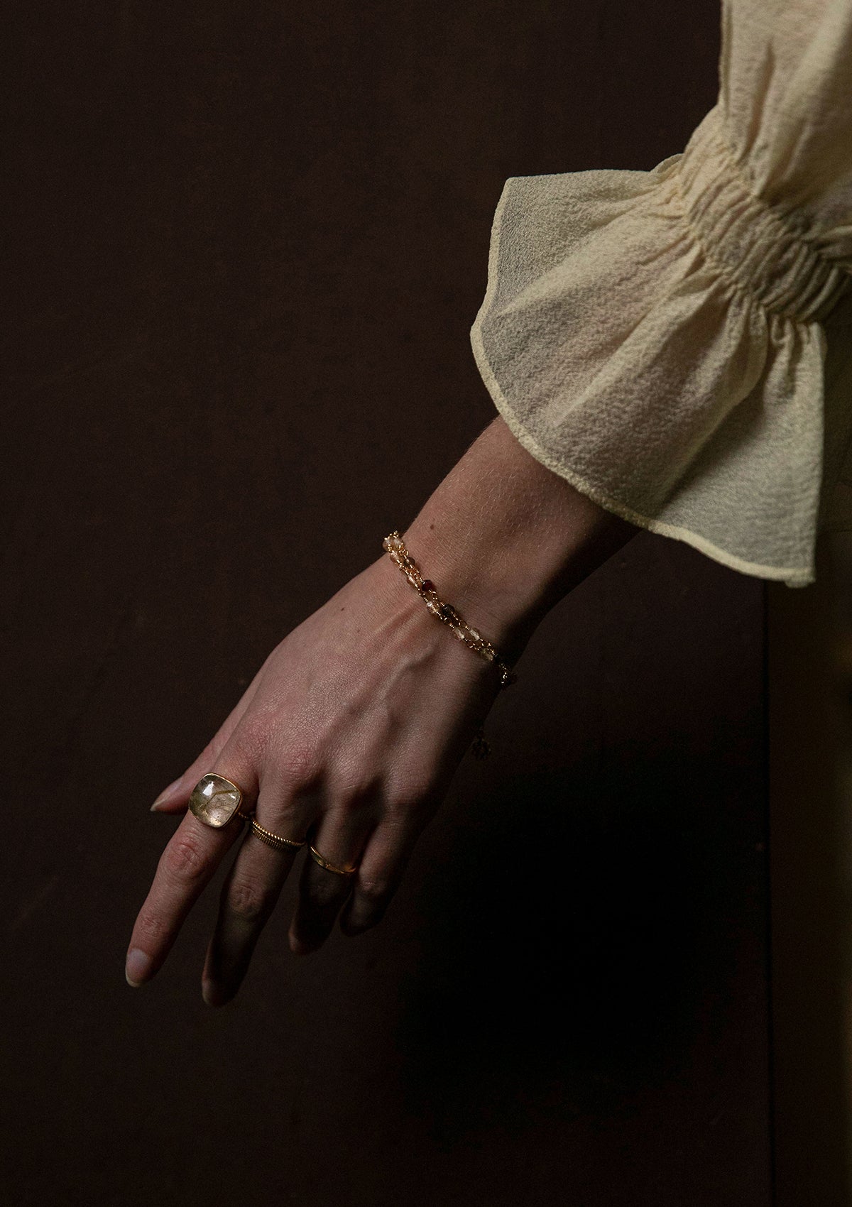 Woman with a large gold ring with a large stone from carré. The stone is a golden rutile quartz