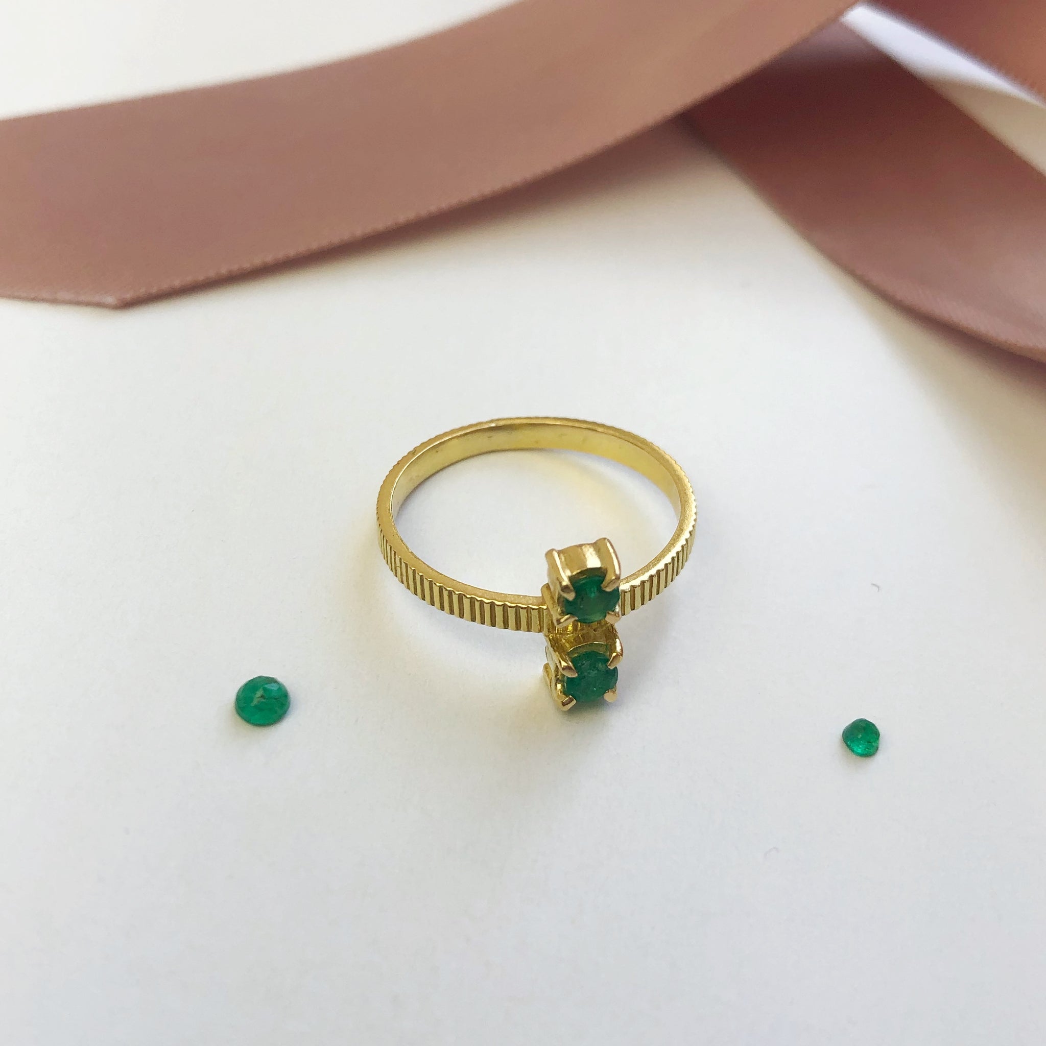 18-karat gold ring from Carré set with two facet-cut green emerald gemstones