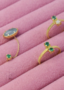 Solid gold rings and double earring with emerald, opal, and aquamarine in a pink jewellery box