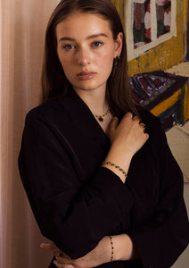 Young woman leaning against a wall wearing black agate jewellery from carré