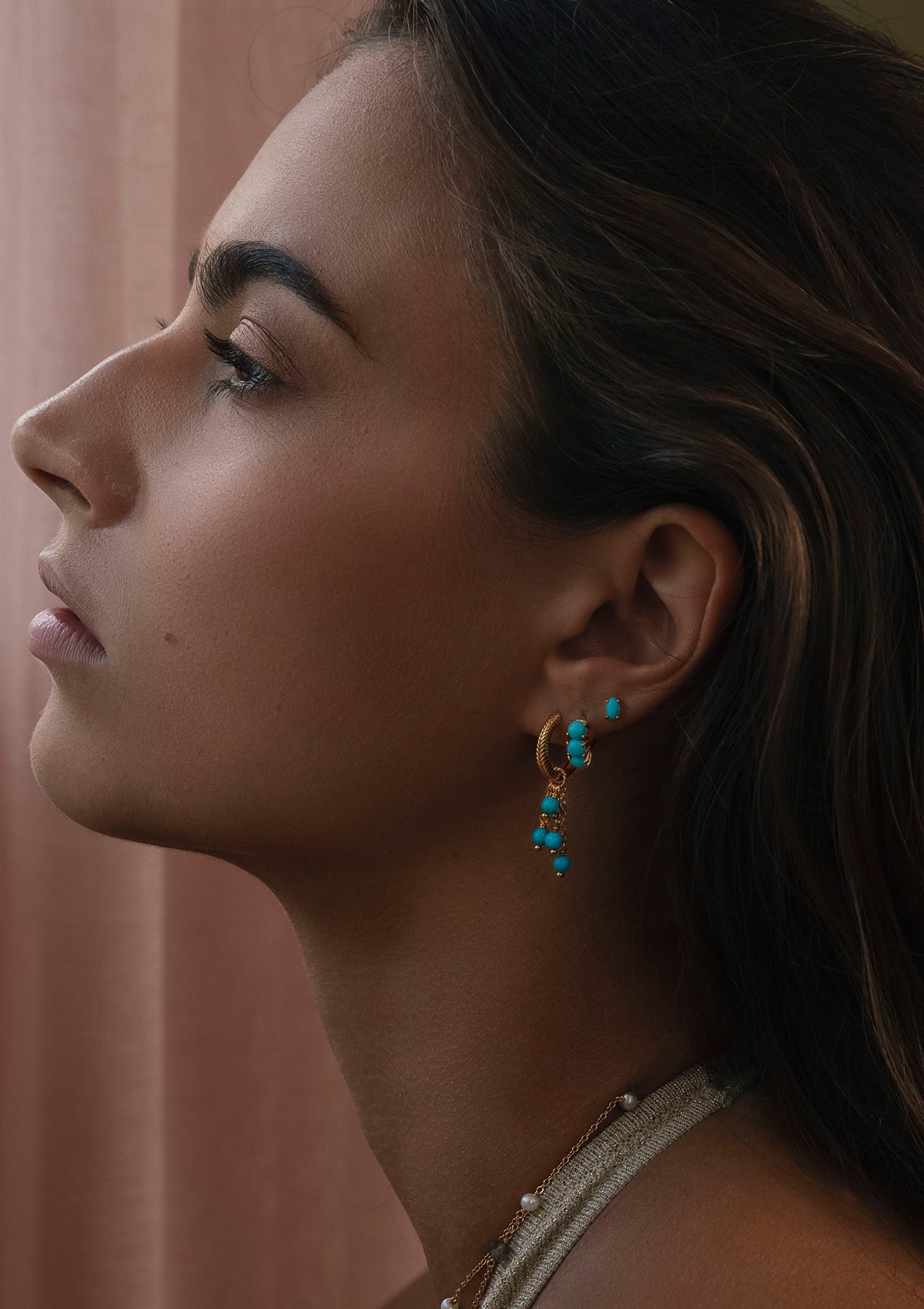 Woman with boho style gold plated earrings with turquoise gemstones from carré